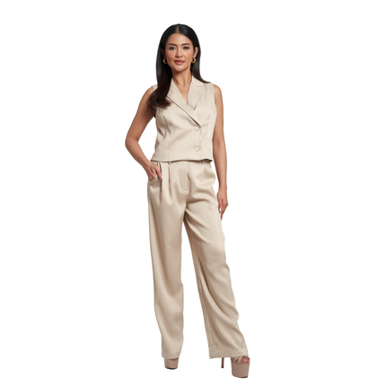 A woman modeling a beige two-piece jumpsuit with a wrap-style sleeveless top and wide-leg trousers, photographed against a plain white background.