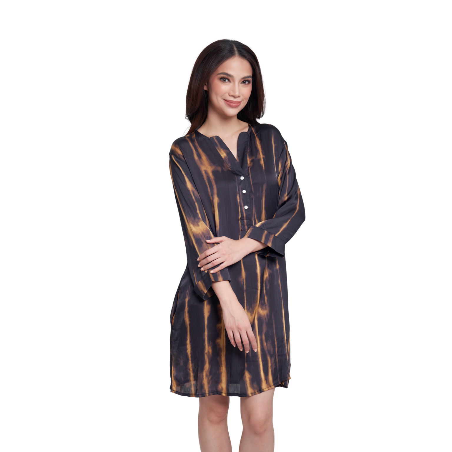 A woman modeling a loose, knee-length tunic dress with a dark navy or black base and vertical warm brown/gold tie-dye stripes, shown against a plain white studio background.