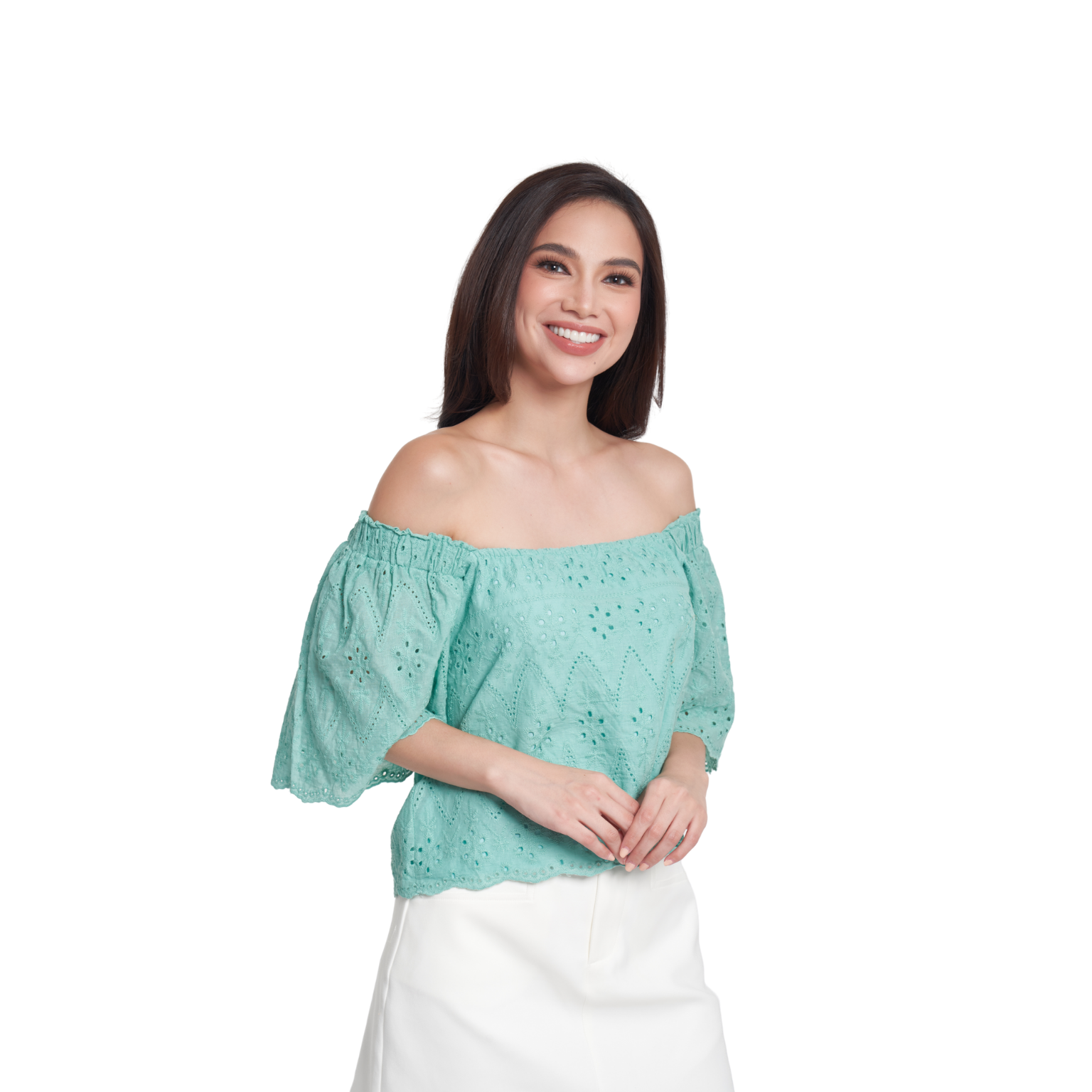 A woman modeling an off-the-shoulder mint green eyelet lace top with puff sleeves, paired with a white skirt, against a plain white background.