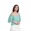 A woman modeling an off-the-shoulder mint green eyelet lace top with puff sleeves, paired with a white skirt, against a plain white background.