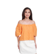 A woman modeling an off-the-shoulder eyelet top in a bright orange color, paired with a white skirt, against a plain white background.