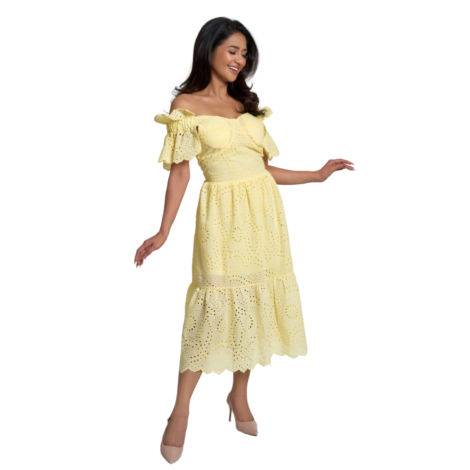 A woman modeling a pale yellow off-the-shoulder eyelet midi dress with ruffled sleeves and a tiered skirt, paired with nude heels, against a plain white background.