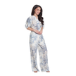 A woman modeling a light blue and white floral print jumpsuit with short puff sleeves and wide legs, set against a plain white background.
