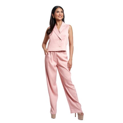 A woman modeling a light pink two-piece suit consisting of a sleeveless double-breasted blazer and matching wide-leg trousers, set against a plain white background.